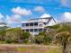 Charming, multi-story coastal home surrounded by lush greenery, showcasing its architectural beauty at 67 Lost Village Trl # 4, Edisto Island, SC 29438