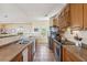 Featuring a long kitchen with bar area, oak cabinets, tile flooring, and stainless steel refrigerator at 67 Lost Village Trl # 4, Edisto Island, SC 29438
