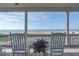 Screened-in porch with white rocking chairs and an ocean view at 67 Lost Village Trl # 4, Edisto Island, SC 29438
