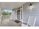 Covered porch with rocking chairs and a view of tropical palm trees at 67 Lost Village Trl # 4, Edisto Island, SC 29438