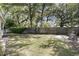 Picturesque backyard with lush grass, mature trees, and a privacy fence creating a serene outdoor retreat at 710 W Harrison Rd, Charleston, SC 29407