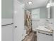 Well-lit bathroom featuring tub and shower with tiled backsplash, sink, and wood-look flooring at 710 W Harrison Rd, Charleston, SC 29407