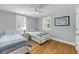 Comfortable bedroom with two twin beds, wood floors, and bright windows that fill the room with natural light at 710 W Harrison Rd, Charleston, SC 29407
