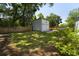 View of the home's backyard showcasing a large, well-maintained lawn, a wood fence, and a detached garage at 81 Avondale Ave, Charleston, SC 29407