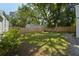 View of the home's backyard showcasing a large, well-maintained lawn and a wood fence for privacy at 81 Avondale Ave, Charleston, SC 29407