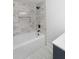 Contemporary bathroom featuring a soaking tub with marble-style tile and a sleek black shower head at 81 Avondale Ave, Charleston, SC 29407