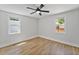 Bright bedroom featuring hardwood floors, modern ceiling fan, and two windows at 81 Avondale Ave, Charleston, SC 29407