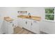 Bright laundry room featuring white cabinets, butcher block countertop, black hardware, and a stainless steel sink at 81 Avondale Ave, Charleston, SC 29407