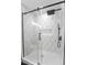 Modern shower featuring white and patterned tiles, a rainfall shower head, and glass doors at 81 Avondale Ave, Charleston, SC 29407