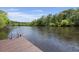 Waterfront property showcasing a wooden dock with a metal ladder for easy access to the tranquil river at 8487 Parkers Ferry Rd, Adams Run, SC 29426