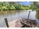 Scenic waterfront view with a charming wooden dock and a decorative birdhouse, surrounded by lush, green trees at 8487 Parkers Ferry Rd, Adams Run, SC 29426