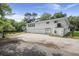 White waterfront home with ample parking, featuring a garage and additional space for vehicles, nestled by a river at 8487 Parkers Ferry Rd, Adams Run, SC 29426