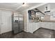 Kitchen area with stainless steel refrigerator, white cabinets, and tiled floors at 8487 Parkers Ferry Rd, Adams Run, SC 29426