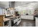Bright kitchen featuring stainless steel appliances, white cabinets, wooden accents, and tiled countertops at 8487 Parkers Ferry Rd, Adams Run, SC 29426
