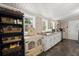 Bright kitchen with white cabinets, stainless steel dishwasher, tiled countertops, and open shelving and storage at 8487 Parkers Ferry Rd, Adams Run, SC 29426