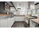 Well-lit kitchen featuring a large stainless steel sink, white cabinets, stainless steel appliances, and tiled countertops at 8487 Parkers Ferry Rd, Adams Run, SC 29426