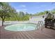 Backyard pool with wooden deck and a white house with a wooden stair structure at 8487 Parkers Ferry Rd, Adams Run, SC 29426