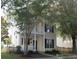 Charming two-story home with a welcoming front porch and balcony, complemented by lush trees and a picket fence at 86 Cross Timbers Dr, Summerville, SC 29485