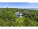 An attractive three-story house with a grassy backyard surrounded by dense trees, providing both privacy and beauty at 912 Cheehaw St, Edisto Island, SC 29438