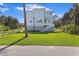 Charming two-story home with light-blue siding, an American flag and a manicured lawn at 912 Cheehaw St, Edisto Island, SC 29438