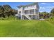 Two-story home with a well-manicured lawn, a stairway leading up to the second floor deck and expansive lawn at 912 Cheehaw St, Edisto Island, SC 29438
