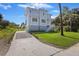 Charming two-story home with light blue siding, lush greenery, and a spacious driveway, great curb appeal at 912 Cheehaw St, Edisto Island, SC 29438