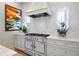 Well-appointed kitchen with stainless steel range, custom cabinets, marble backsplash and plenty of natural light at 912 Cheehaw St, Edisto Island, SC 29438
