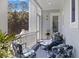 Cozy covered porch showcasing blue furniture, outdoor lighting, and peaceful landscape for comfortable relaxation at 912 Cheehaw St, Edisto Island, SC 29438