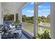 Stylish covered porch featuring chic blue furniture, green landscaping, and views for tranquil outdoor enjoyment at 912 Cheehaw St, Edisto Island, SC 29438