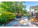 Outdoor patio with seating area surrounded by lush greenery and a palm tree at 1187 Out Of Bounds Dr, Summerville, SC 29485
