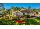 A stunning backyard with lush green grass, colorful landscaping, and mature palm trees at 1187 Out Of Bounds Dr, Summerville, SC 29485