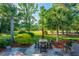 Enjoy the serene backyard patio with a dining set, surrounded by lush greenery and mature palm trees at 1187 Out Of Bounds Dr, Summerville, SC 29485