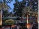 Serene twilight scene on a patio with outdoor dining, illuminated by the soft glow of landscape lighting at 1187 Out Of Bounds Dr, Summerville, SC 29485