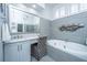 This bathroom features a soaking tub, tiled walls, and a chair near the vanity at 1187 Out Of Bounds Dr, Summerville, SC 29485