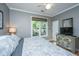 Comfortable bedroom features a ceiling fan, a window overlooking green foliage, and a gray color scheme at 1187 Out Of Bounds Dr, Summerville, SC 29485