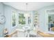 Bright breakfast nook features a glass table, four chairs, and large windows overlooking a beautifully landscaped yard at 1187 Out Of Bounds Dr, Summerville, SC 29485