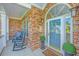 Inviting brick front porch with rocking chairs and arched glass front door at 1187 Out Of Bounds Dr, Summerville, SC 29485