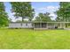 Expansive backyard showcasing the home, a screened-in porch, carport, and lush green lawn, ideal for outdoor activities at 1210 Azalea Dr, Summerville, SC 29483