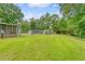 Large backyard featuring a lush green lawn, storage sheds, and mature trees, offering a private outdoor space at 1210 Azalea Dr, Summerville, SC 29483