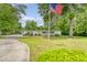 Well-maintained single-story home with a lush front yard and mature trees, with driveway and carport at 1210 Azalea Dr, Summerville, SC 29483