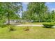 Well-maintained single-story home with a lush front yard and mature trees, with driveway and carport at 1210 Azalea Dr, Summerville, SC 29483