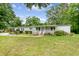 Charming single-story home with a well-manicured lawn and inviting front porch, surrounded by lush greenery at 1210 Azalea Dr, Summerville, SC 29483