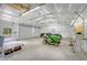 Well-lit garage featuring a lawn mower, black car, and ample space for equipment and vehicles at 1210 Azalea Dr, Summerville, SC 29483