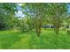 Large backyard of a blue one-story home with mature trees, providing plenty of shade at 1222 Maxwell St, North Charleston, SC 29405