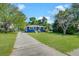 Quaint blue house with white trim, set back from the street with a long driveway and mature trees at 1222 Maxwell St, North Charleston, SC 29405