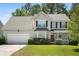 Charming two-story home boasts well-maintained landscaping, a red door, and a two-car garage at 1223 Creek Stone Way, Hanahan, SC 29410