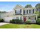 Attractive two-story home with an attached garage, beautiful landscaping, and a welcoming front porch at 1223 Creek Stone Way, Hanahan, SC 29410