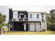 Charming elevated home with a crisp black and white exterior and a relaxing outdoor deck at 126-C Jungle Rd, Edisto Beach, SC 29438