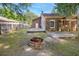 Backyard view of a brick house with a wooden deck, and a brick firepit at 1383 W Lenevar Dr, Charleston, SC 29407
