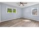Bright bedroom features two windows, ceiling fan, and wood-look flooring at 1383 W Lenevar Dr, Charleston, SC 29407